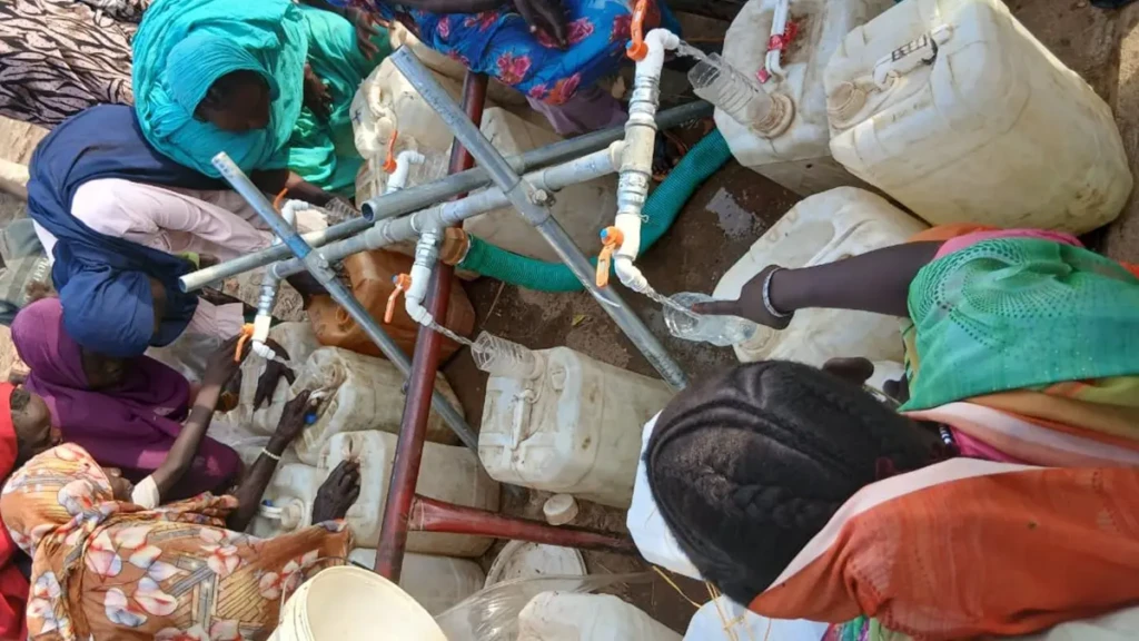 Mujeres recogen agua en un punto de distribución en los campamentos de Al Safa, Abu Jubayhah, Kordofán del Sur.