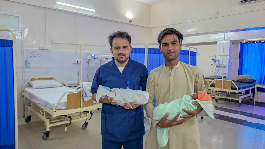 Nizam Khan, tío de los gemelos y un enfermero de MSF cargana los bebés antes de ser dados de alta. Hospital Dogra, Pakistán. © Gul Nayab .