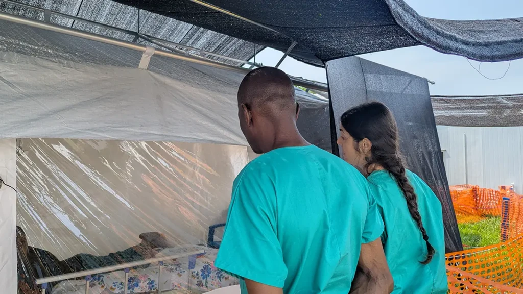Psicólogos de MSF hablan con un paciente aislado como caso sospechoso de ébola en el Centro de Tratamiento de Ébola del Hôpital du Cinquantenaire en Kisangani, provincia de Tshopo, el 27 de agosto de 2026.