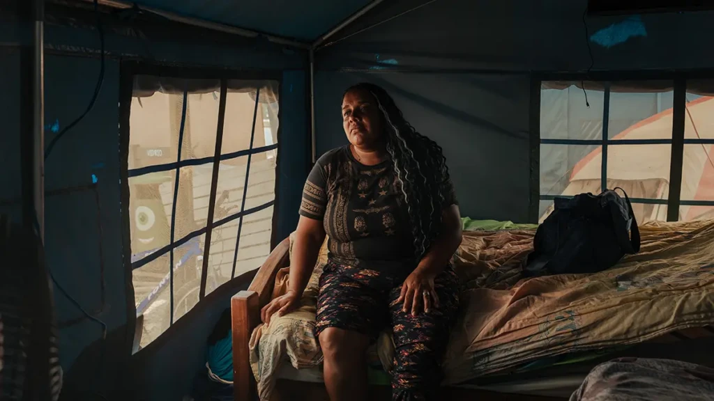 Ashley Mayora, de 43 años, está sentada en su tienda de campaña con un tobillo lesionado. La familia vive en un campamento provisional instalado en las afueras de Mare Abajo, un complejo habitacional que se derrumbó parcialmente durante el doble terremoto.