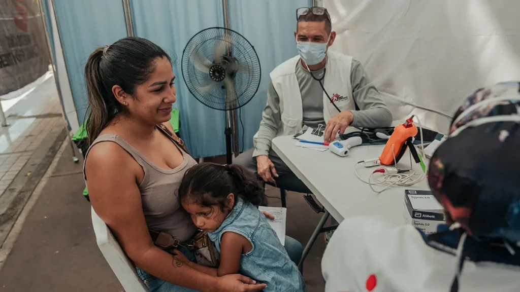Jhennifer Cárdenas, y su hija Victoria Serrano, durante una consulta médica en una carpa de MSF en la Avenida Bolívar.