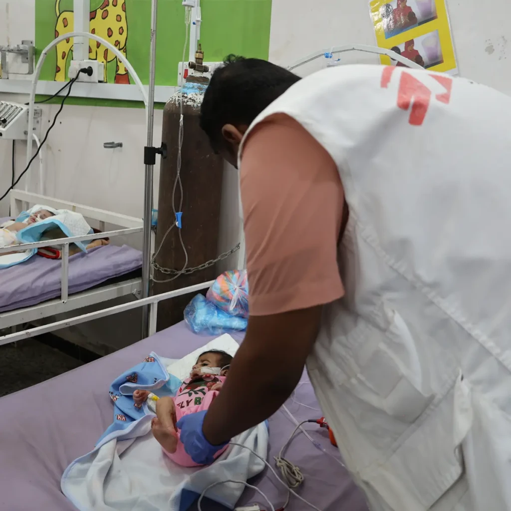 Ali Jarbain, supervisor de MSF en el centro de alimentación terapéutica para pacientes hospitalizados (ITFC), supervisa el estado de salud de un niño ingresado hace unos días en el Hospital General de Abs, Yemen. © Majdi Al Adani/MSF