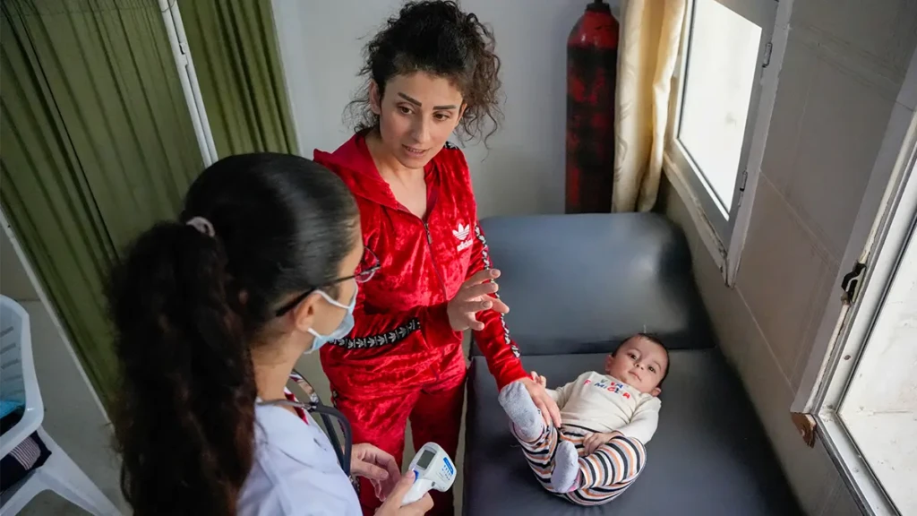 Una doctora de la Dirección General de Sanidad examina a un bebé en el centro de atención primaria de salud de Al-Qutaylibiyah, que cuenta con el apoyo de MSF. Provincia de Latakia, Siria.