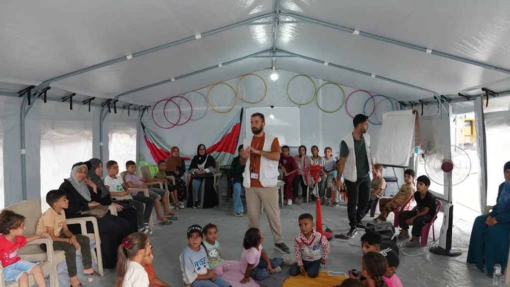 Mahmoud Al-Balbisi, consejero de salud mental de MSF, dirige una sesión para niños y cuidadores dentro de una tienda de carpa en la clínica Zaytoun. Gaza, Palestina, agosto de 2026.