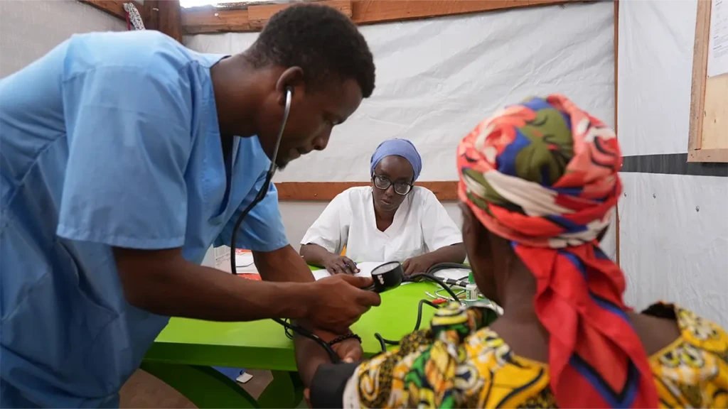 Los refugiados en el campo de Busuma enfrentan condiciones duras En el centro de salud de MSF en el campo de refugiados de Busuma, los equipos médicos examinan a un joven paciente acompañado por su madre en la sala de consultas.