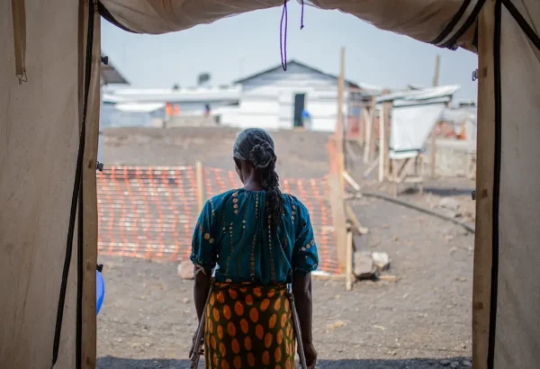 Una mujer se encuentra en la puerta de la clínica de MSF donde se atiende a víctimas y sobrevivientes de violencia sexual en el campo de personas desplazadas de Bulengo, Kivu Norte, República Democrática del Congo, agosto de 2023. © Alexandre Marcou/MSF