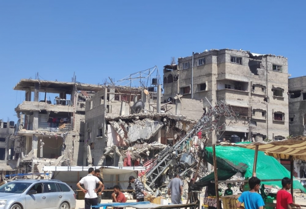 Un grupo de personas frente a un edificio bombardeado en Rafah, Gaza.