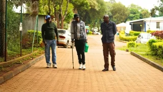 Mburu Michael con su papáy su tío cuando llegan a la clínica de terapia médicamente asistida (MAT).