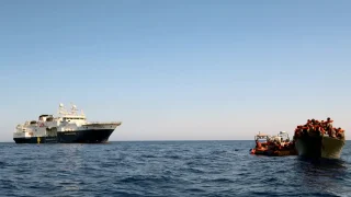 Vista del Geo Barents acercándose aun barco de madera para realizar un rescate de 130 personas.