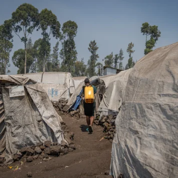 Una mujer cargando un bidón de agua por un campo de personas desplazadas en Goma, República Democrática del Congo.