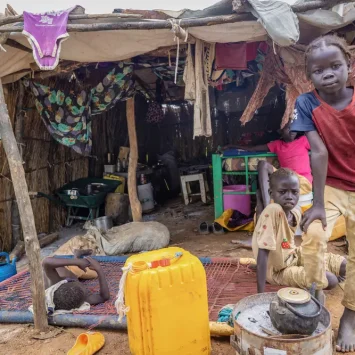 Los hijos de Elizabeth frente a su refugio en la carretera en Abyei, tras la inundación que sumergió su anterior hogar el 22 de agosto.