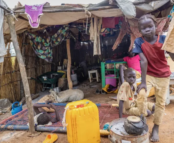 Los hijos de Elizabeth frente a su refugio en la carretera en Abyei, tras la inundación que sumergió su anterior hogar el 22 de agosto.