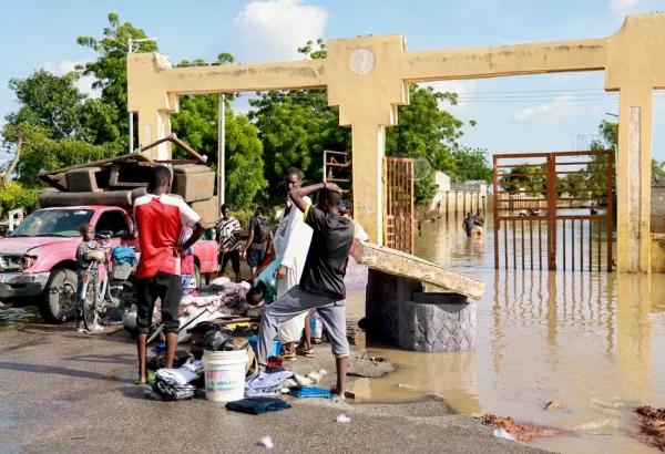 Las personas afectadas por las inundaciones en Nigeria cargan sus pocas pertenencias.