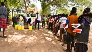 Como medida deprevención de la malaria, as personas se forman durante la distribución de mosquiteros en la aldea de Nasorot en Baringo, Kenia.