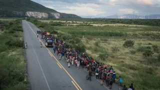 Una caravana de migrantes escoltada por policías avanza por la ruta entre las localidades de La Venta y Juchitán, en el sur de México.