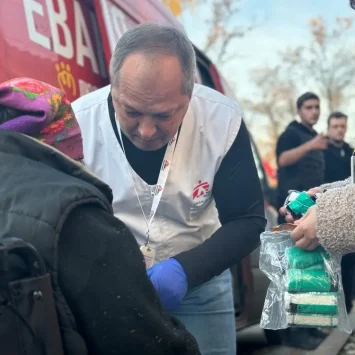 El médico de MSF Oleksandr Hontariev realiza un tratamiento quirúrgico inicial en el brazo de un paciente. Cerca del centro de tránsito, donde tenemos nuestra clínica móvil